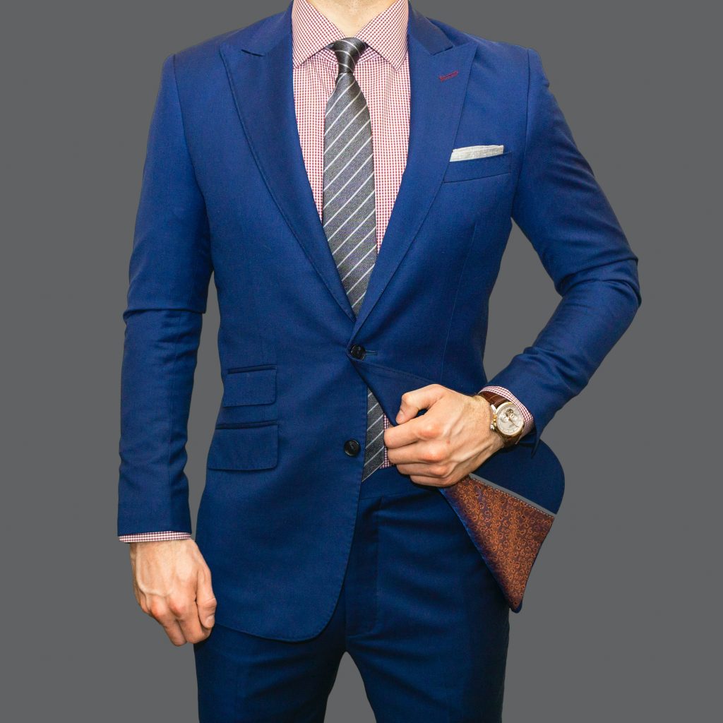 A man wearing a solid coloured suit. 