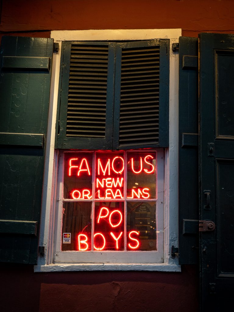 Red sign in window: Famous New Orleans Po Boys. BUKU also offers authentic Louisiana cuisine.
