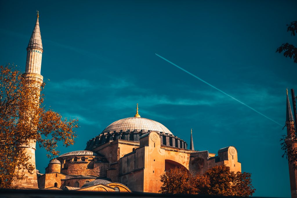 A plane flying far over the Hagia Sofia in Istanbul. 