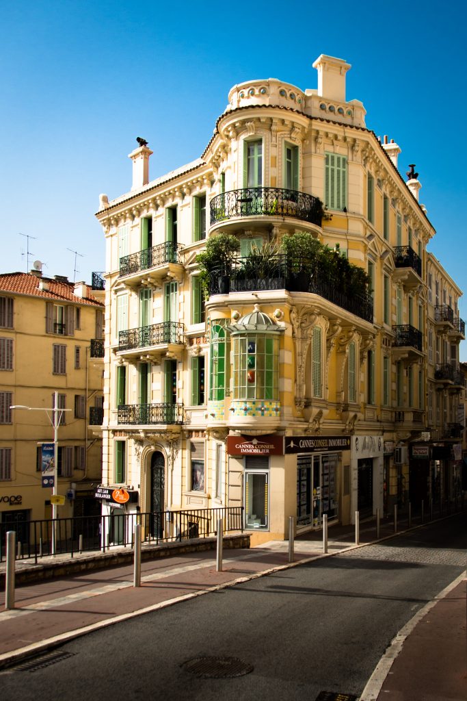 Cannes, France. A yellow building on a street corner. 